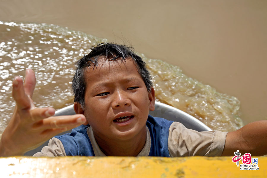 水上人家划着盆子来乞钱的小男孩