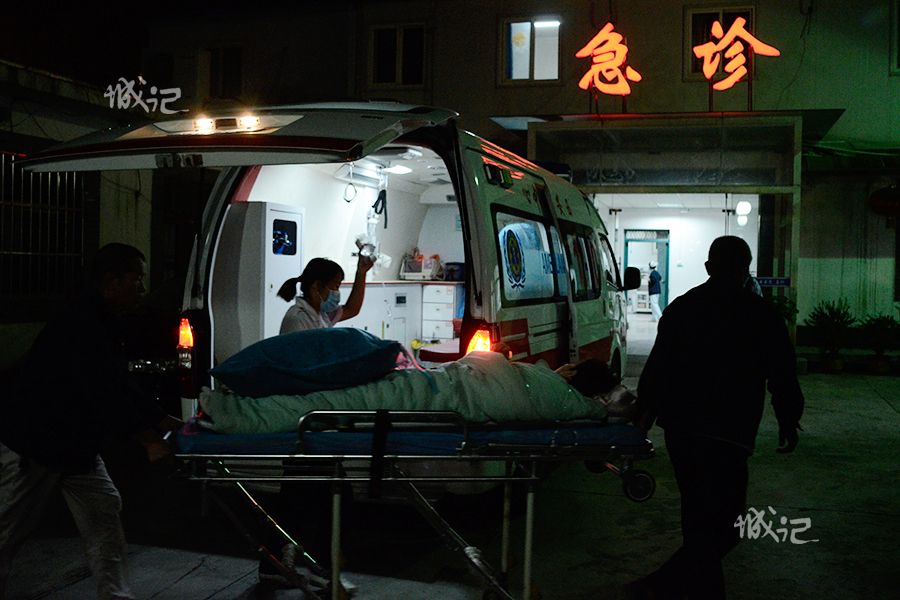 急救人员将老人从救护车上抬下,用担架送往医院急诊科.