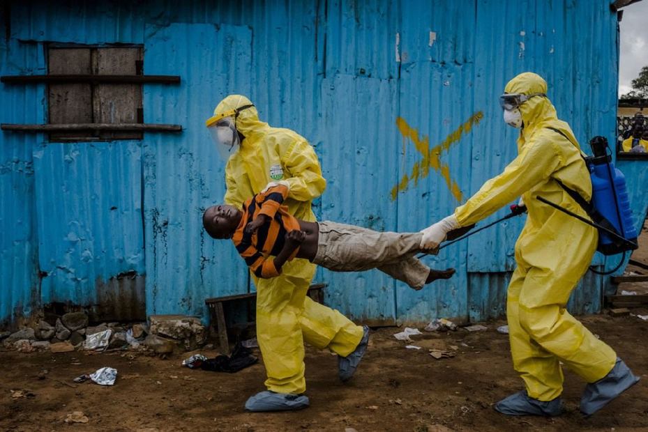 2014年9月5日，在賴比瑞亞首都蒙羅維亞，醫護人員抬著8歲的埃博拉疑似感染者詹姆斯·多波爾衝進治療中心。由於醫護人員沒有穿埃博拉防護服，所以他們只能這樣抬著詹姆斯，以將埃博拉病毒的傳染性降至最低。