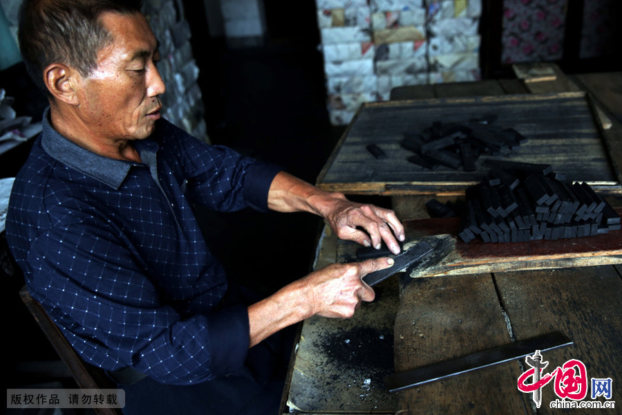 安徽省黄山市制作传统徽墨打磨徽墨边角。