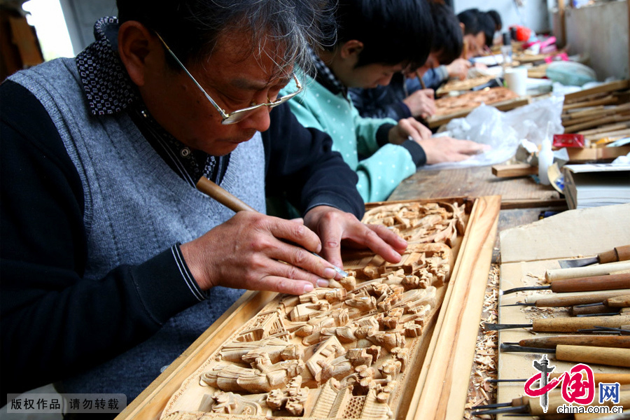 安徽省黄山市民间工匠正以锋利的手工工具刻凿装饰木质物上精美图案。