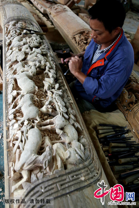 安徽省黃山市民間工匠正在雕刻古建築裝飾木質物上精美圖案。