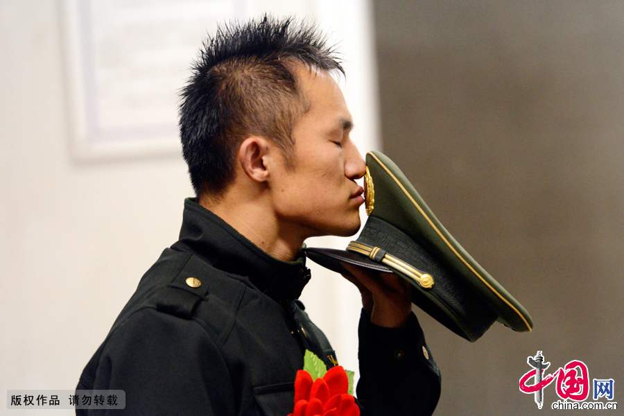 图为11月24日，武警江苏总队一支队一名退伍老兵依依不舍的亲吻军帽，告别军营。