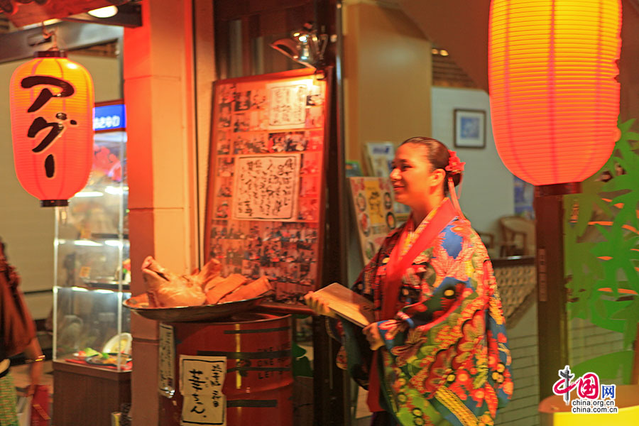 烤肉店外站着迎客员工身着琉球传统服饰