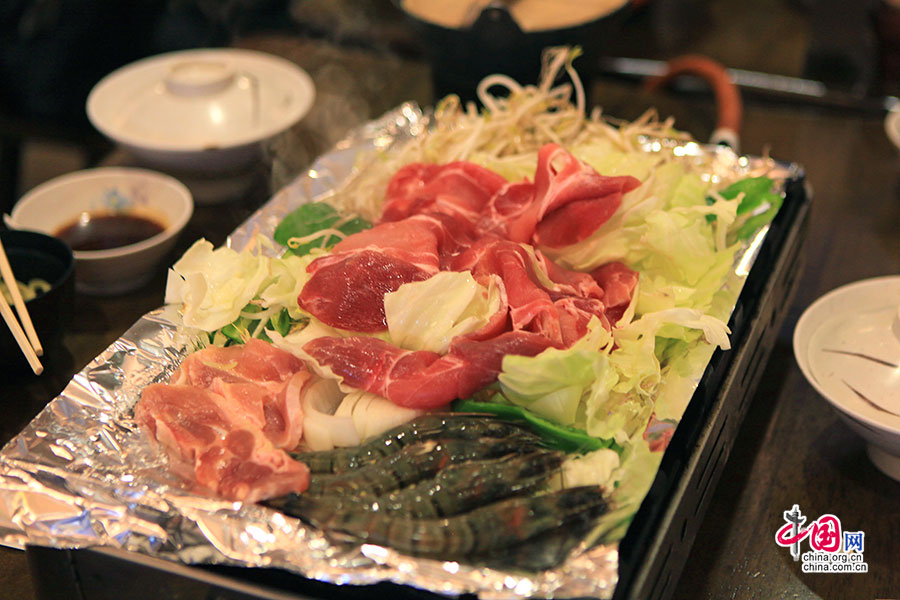 日式烧烤将蔬菜铺下、鱼肉放上