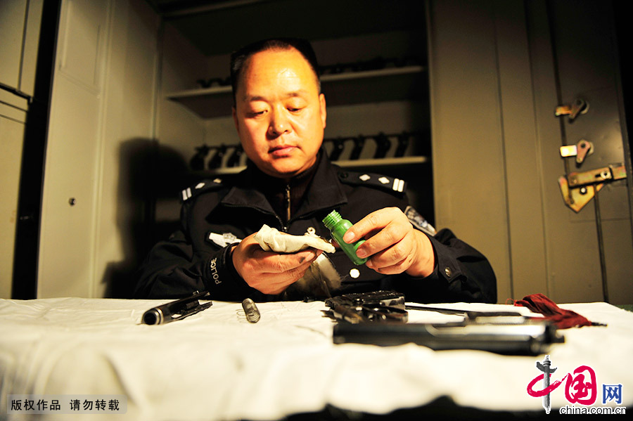 对一把警用手枪进行养护前，郑天禄做好准备工作。中国网图片库 王伟/摄