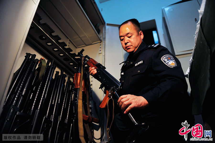 在枪械库内，郑天禄对警用冲锋枪存放区进行摆放顺序和标签的整理。中国网图片库 王伟/摄