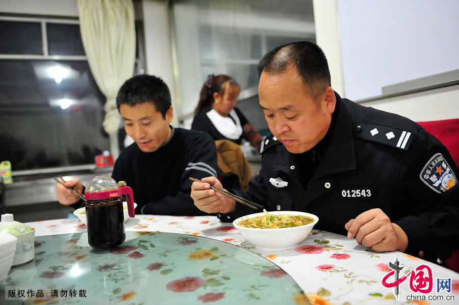  郑天禄在单位食堂与同事一起吃晚饭，他的晚饭是一碗刀削面。在枪械员的工作中，加班是家常便饭，有时特警出去执行任务凌晨返回，郑天禄要等候他们返回后把枪械全部入库后才能回家。中国网图片库 王伟/摄