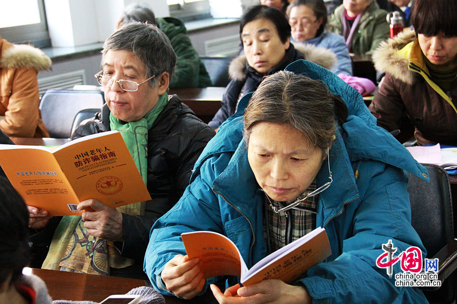 2014年12月10日，全国老龄工作委员会办公室、公安部联合在京举行《中国老年人防诈骗指南》首发仪式。图为参与活动的老年人被指南中的内容所吸引。 中国网记者 戴凡/摄影