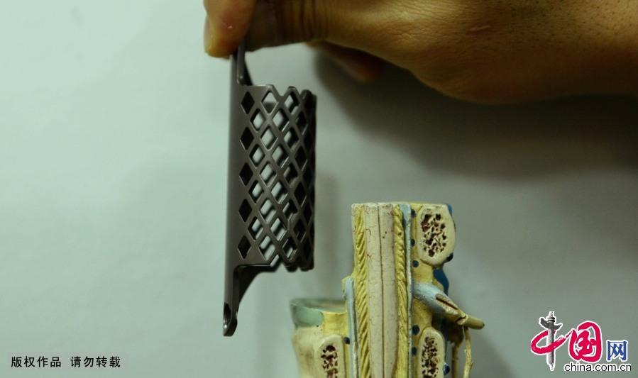 2014年12月11日，浙江省杭州市，在一段教学用的脊椎模型旁，浙江大学附属第一医院骨科医生向人们介绍用3D激光打印技术制成的钛合金人工椎体所治换坏死的椎体位置。