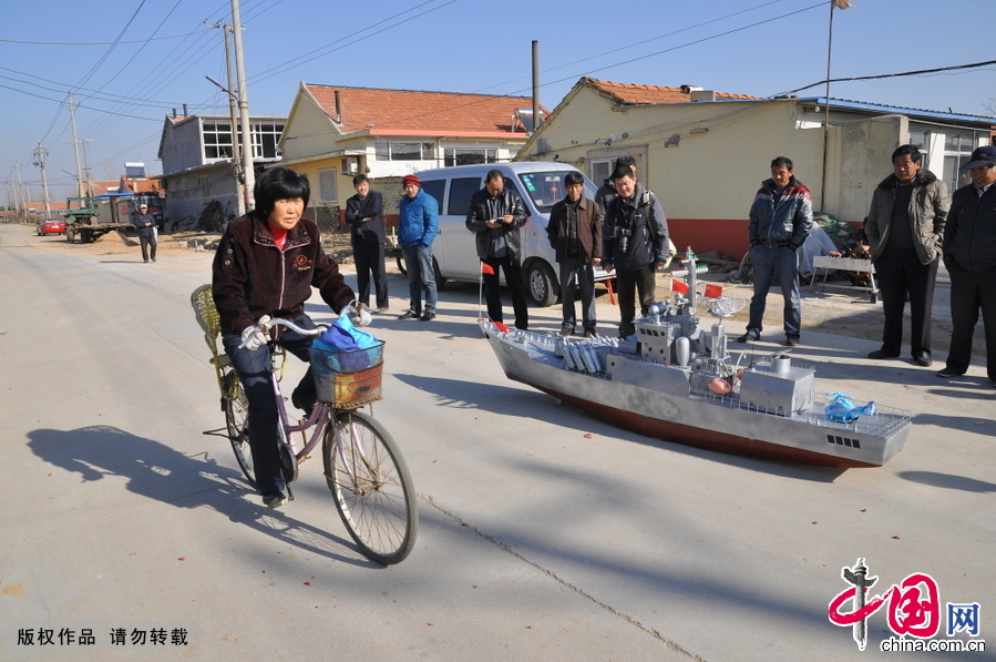 2014年12月13日，山东省日照市山海天旅游度假区肖家村，村民郭长海正在大街上向村民和过路行人展示他的新作“导弹护卫舰”。在近一个小时的展示时间里，“导弹护卫舰”的出色表演，吸引了众多村民和行人的围观。
