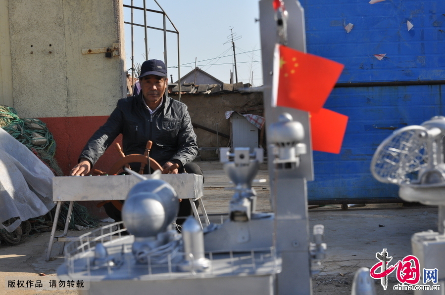 2014年12月13日，山東省日照市山海天旅遊度假區肖家村，村民郭長海正在大街上向村民和過路行人展示他的新作“導彈護衛艦”。在近一個小時的展示時間裏，“導彈護衛艦”的出色表演，吸引了眾多村民和行人的圍觀。