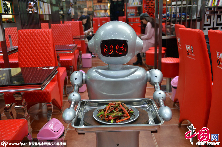 2014年12月13日，成都，四川省第一家以机器人为主题元素打造而成的餐厅在成都开业。近10台造价达7万元人民币的机器人在餐厅内来回穿梭为客人提供各种饮食服务，这些机器人身怀多种绝技，除了端盘子、传菜以外，还可以和客人进行简单的问候和打招呼。图片来源：CFP