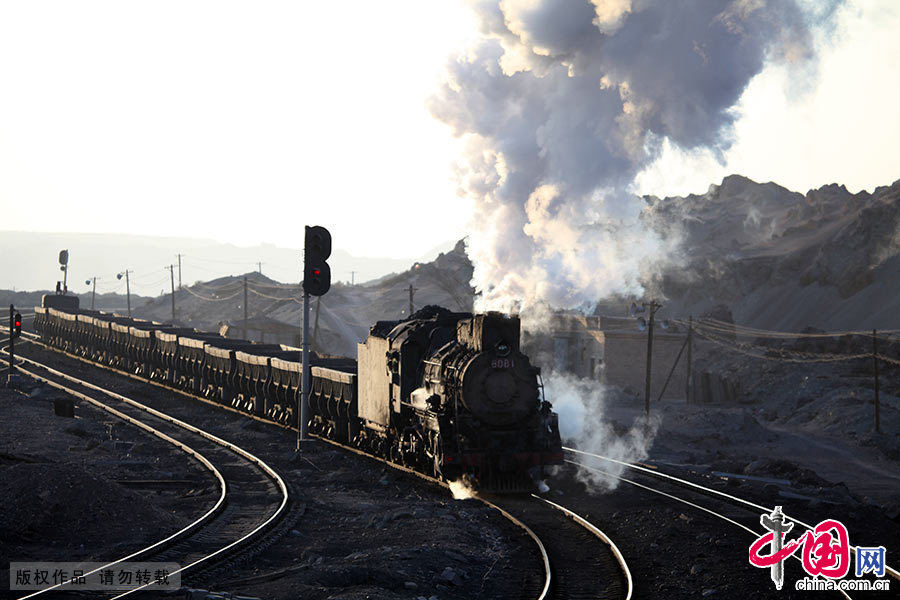 庞大的蒸汽机车喷着蒸汽水雾，伴随着哐当哐当的吼声穿行在运输线上。中国网图片库 孙继虎/摄