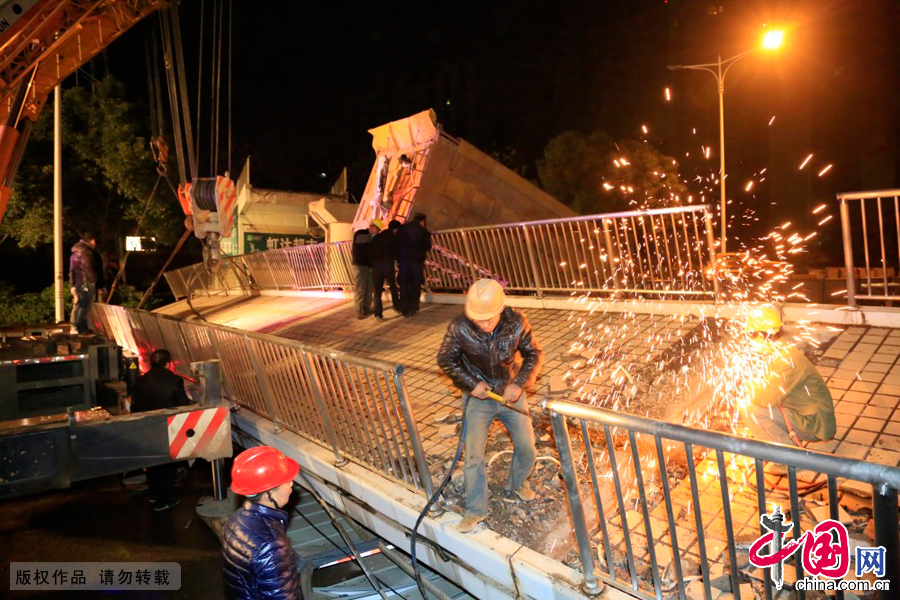 12月18日，救援人員對湖南省長沙市萬家麗路月湖公園附近人行天橋垮塌的橋面進行切割。 中國網圖片庫 郭國權攝影