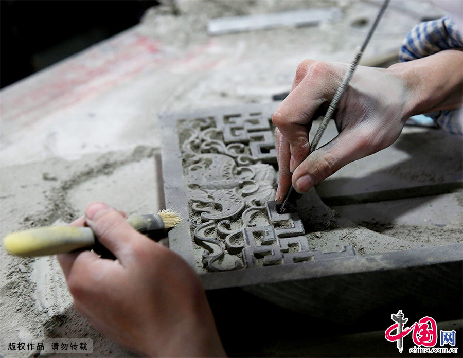 徽州工匠正运用传统的手工技艺在一块青灰砖上精雕细琢。中国网图片库 吴孙民/摄