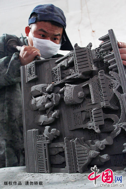 徽州工匠正运用传统的手工技艺在青灰砖上雕刻处理。中国网图片库 吴孙民/摄
