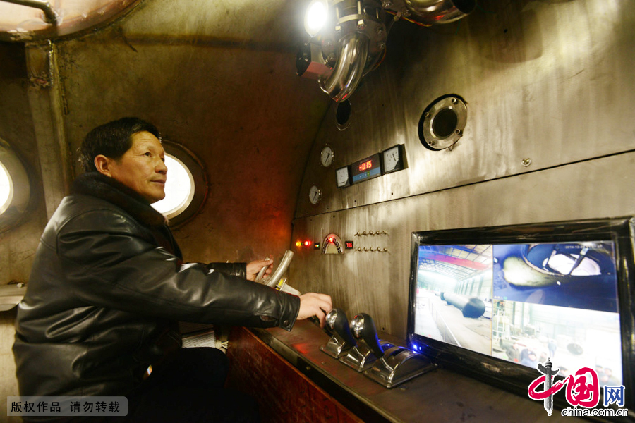 2014年12月20日，在安徽阜阳市一集团的金工车间，张俊林在查看“神龙三号”潜艇舱内仪表。 中国网图片库安新摄影