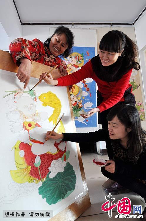 黄颖在指导两个女儿创作手绘年画。受黄颖的影响，她的一对女儿也都喜爱画画。中国网图片库 郝群英/摄 