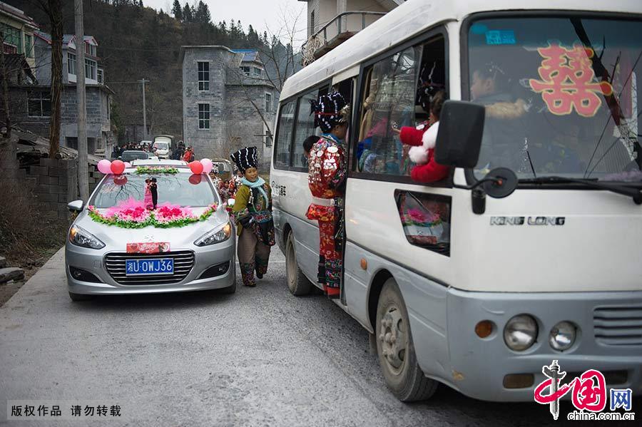 下午，新娘龍玉婷乘坐花車在十余個盛裝紅衣伴娘陪同下離開娘家，去六公里外的禾庫鎮夫家。中國網圖片庫 尹忠/攝 