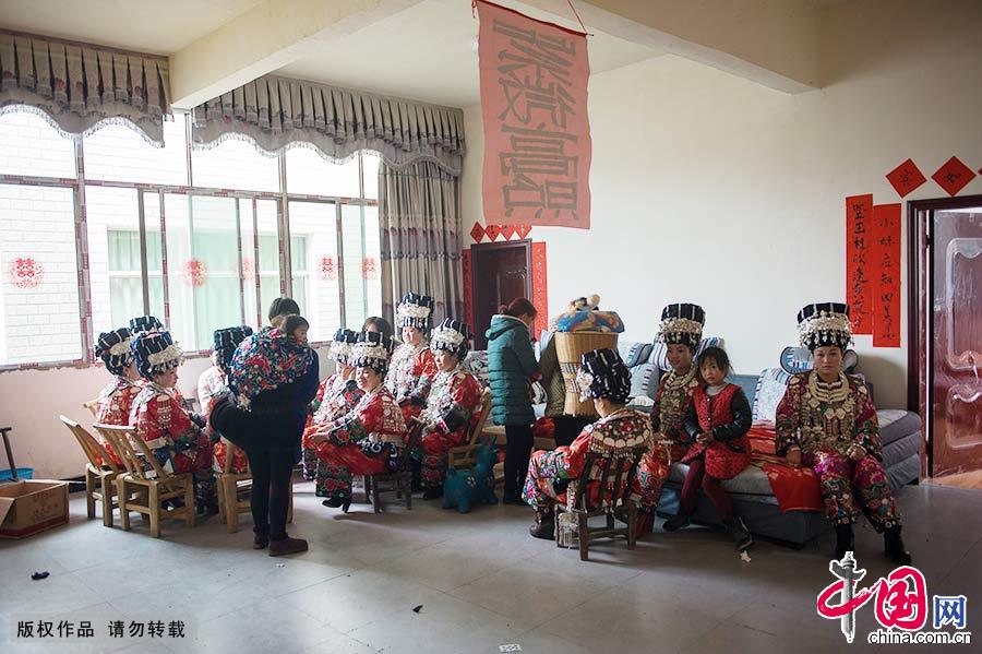 在湘西鳳凰縣禾庫鎮新郎家，也坐著十余個身著盛裝，戴滿銀飾的婦女，耐心等待迎親車隊的到來。中國網圖片庫 尹忠/攝 