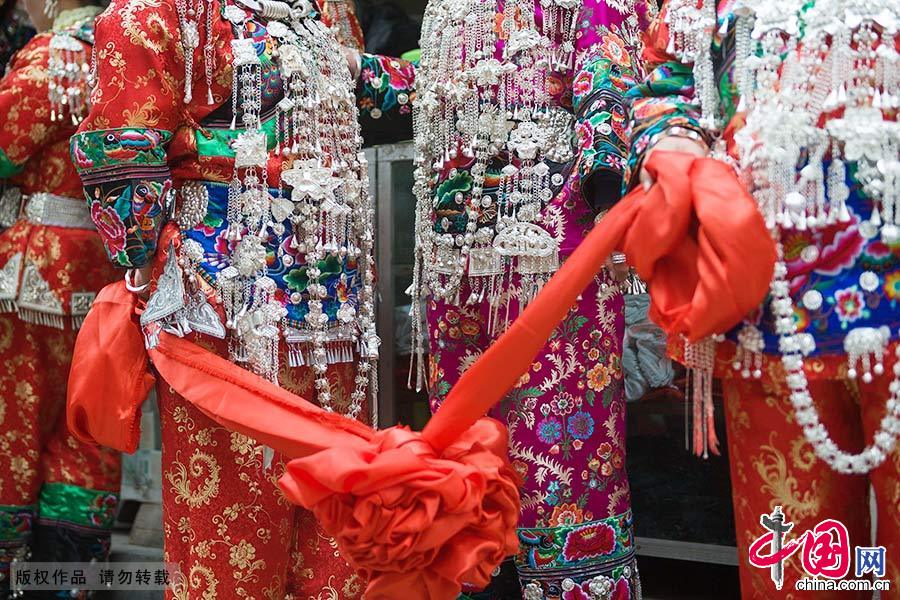 得知新娘将要到来，这十余个身着盛装，戴满银饰的妇女拿着红绸来到镇上。 中国网图片库 尹忠/摄 
