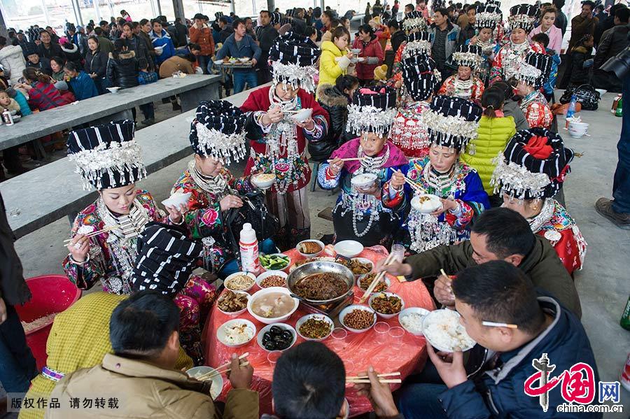 喝了拦门酒已是晚饭时间，新郎家在镇上的服装市场设下百桌宴席款待赶来庆贺的亲朋好友。中国网图片库 尹忠/摄 