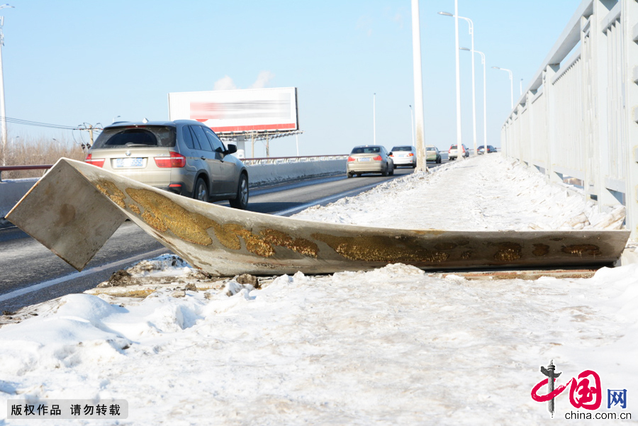 2015年1月6日,吉林省吉林市，在吉林市雾凇大桥上,车辆从损坏后高高翘起的大桥钢板前驶过。 中国网图片库王凯冬摄影