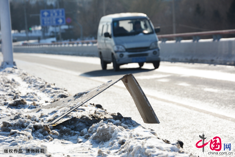 2015年1月6日,吉林省吉林市，在吉林市霧凇大橋上,車輛從損壞后高高翹起的大橋鋼板前駛過。 中國網(wǎng)圖片庫王凱冬攝影