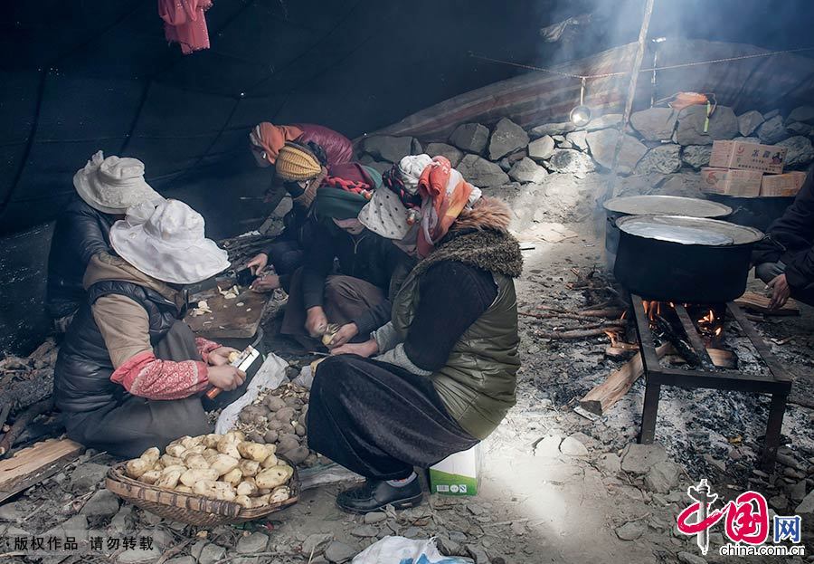 到了饭时，妇女们放下刻石工具，在搭建的临时帐篷里生火做饭。中国网图片库 刘国兴/摄