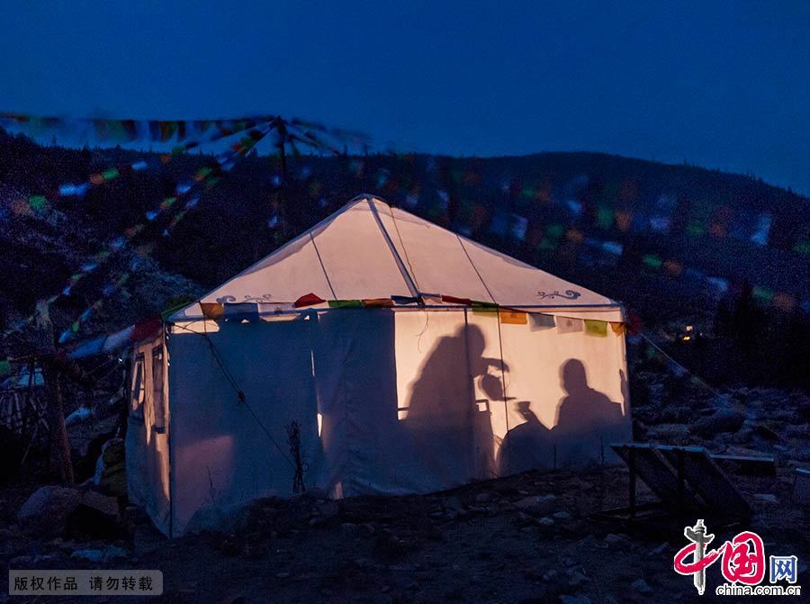 晚饭后，住在帐篷里的旺姆大妈给老伴格西倒茶，虽然艰苦但温馨。中国网图片库 刘国兴/摄