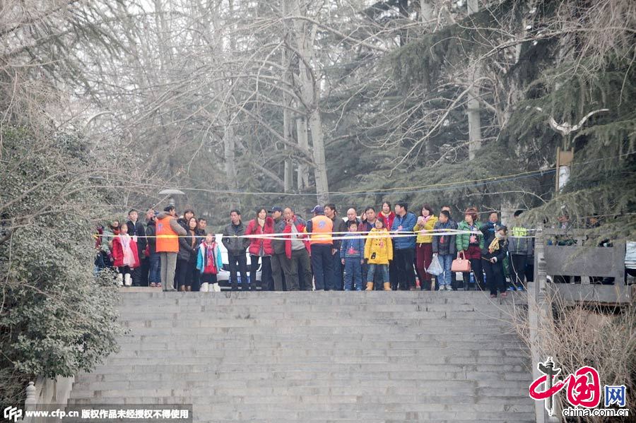  2015年1月17日，河南三门峡天鹅湖游览区被当地政府彻底关闭，游客被禁止入内。工作人员在禁区附近巡逻执勤。而天鹅还在附近飞翔。 图片来源：CFP