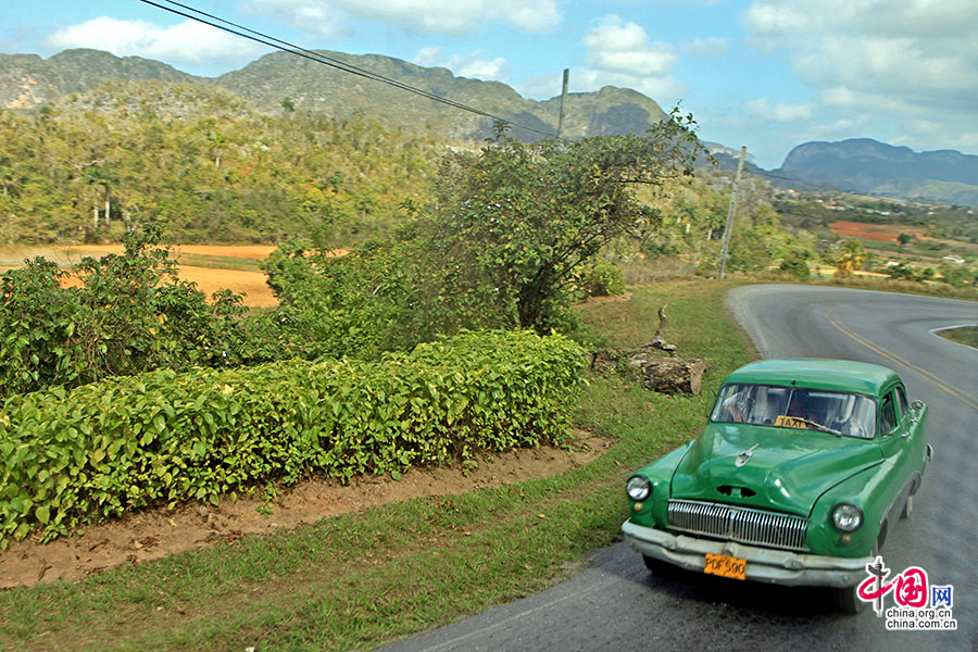 3行驶在山峦青翠的古巴乡村的老爷车是TAXI