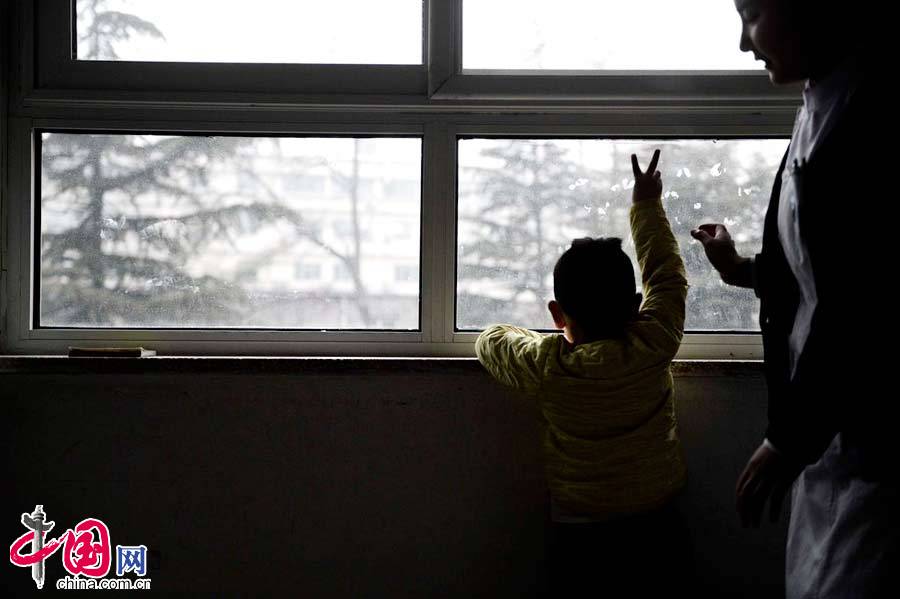 2015年1月14日，北京，病房里的特特看到窗外的人们，高兴的打招呼。 图片来源：CFP