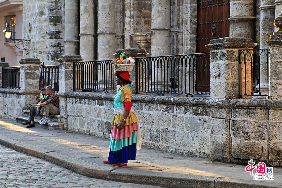 衣着鲜艳、头顶花果篮的古巴女人
