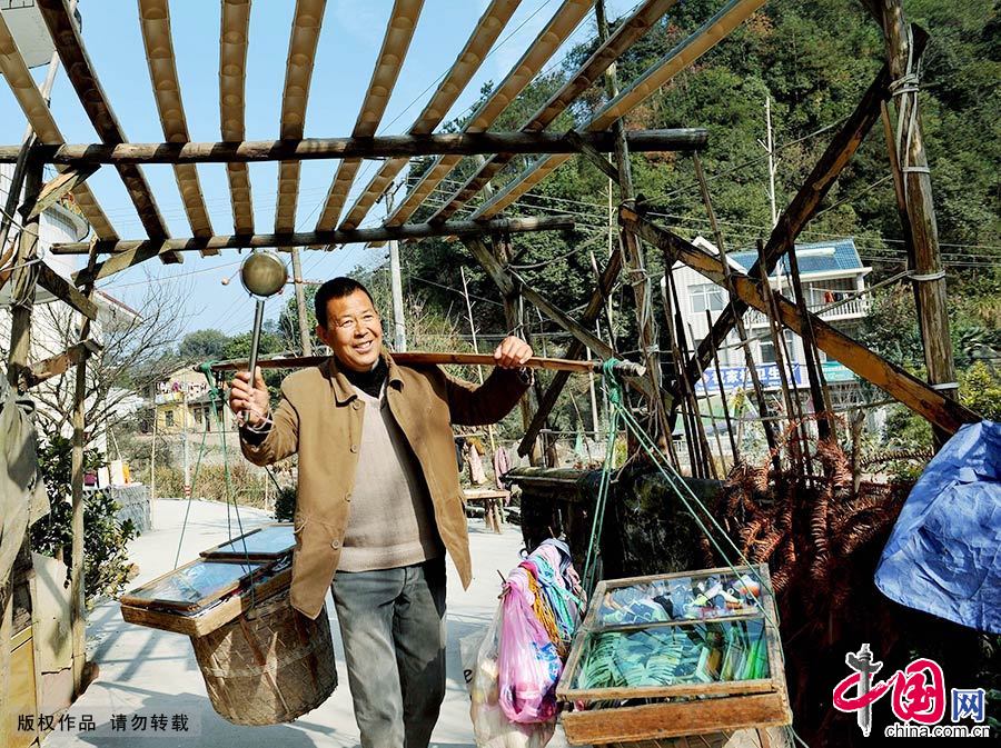 在江西省德興市，貨郎擔唐海松挑著跟隨自己30多年的貨郎擔，轉打小小撥浪鼓，跋山涉水走村串戶賣雜貨。中國網圖片庫 卓忠偉/攝