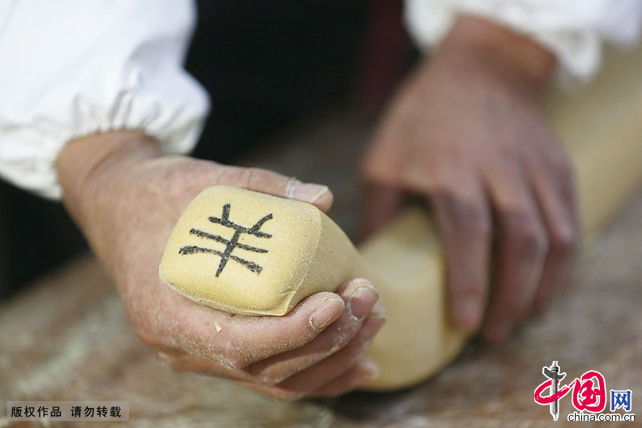 一名制糖艺人正在制作“羊”字古徽州字豆糖。中国网图片库 施亚磊/摄