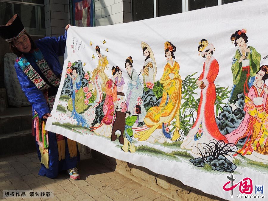 一名土家妇女展示历时三年而成的刺绣成品《金陵十三钗》。