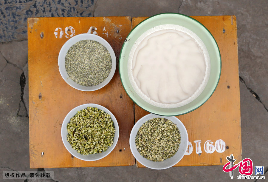 2015年02月07日，安徽省蚌埠市，固鎮縣濠城鎮丁流魁夫婦正在使用傳統手工製作麵食綠豆餅。製作綠豆餅使用的食材，綠豆和豬油。 