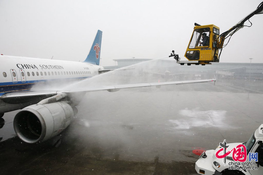 2015年1月27日，陜西西安，入冬後的首場大雪降臨西安咸陽國際機場，為確保飛機安全，在起飛前機務人員給飛機進行除冰雪作業