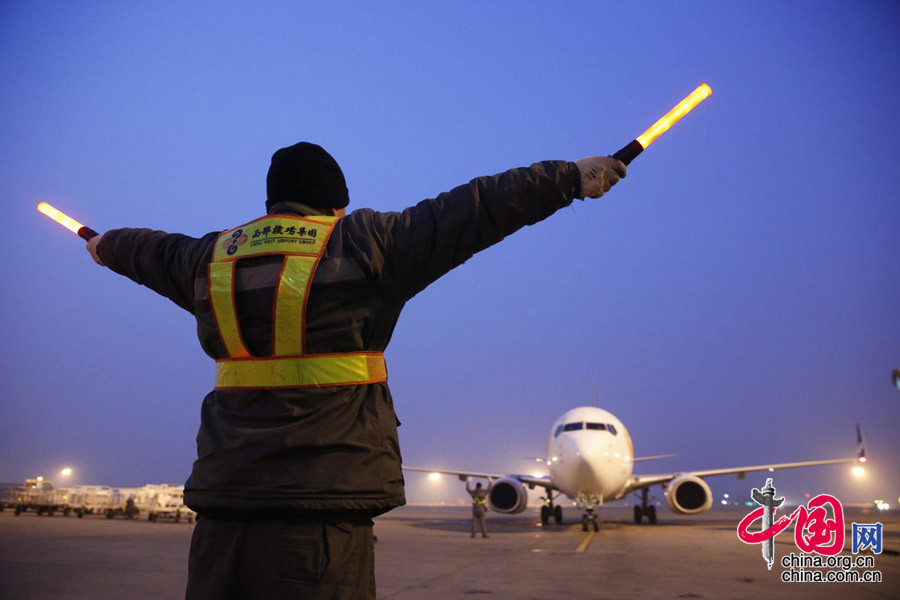 2015年2月3日晚6時，陜西西安，機務人員按照標準指揮信號,指引機組人員完成飛機的轉彎、滑行、停止、關閉發動機等一系列程式
