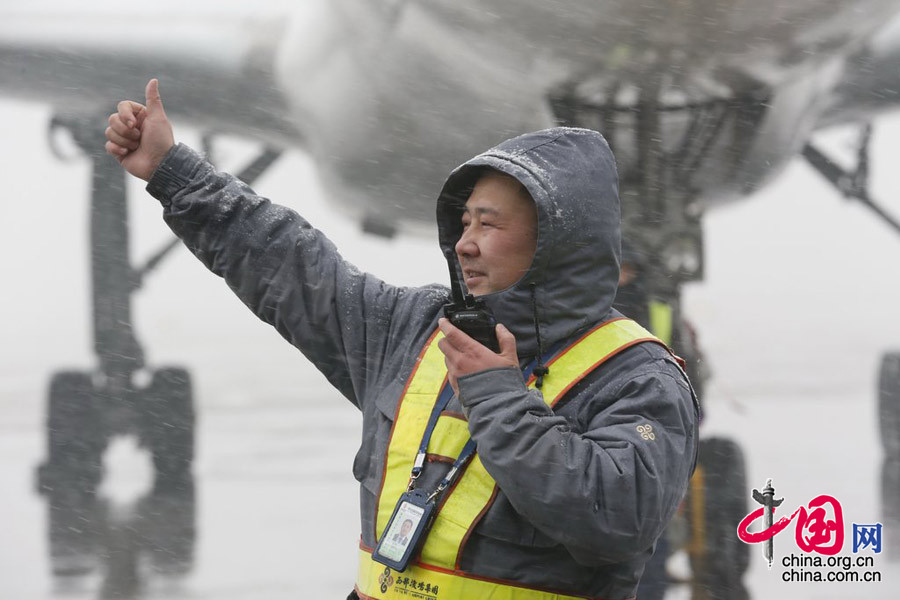 2015年1月27日，陜西西安，機務人員冒雪調配設備，全力做好除冰雪工作，確保飛機安全正點，旅客出行順暢