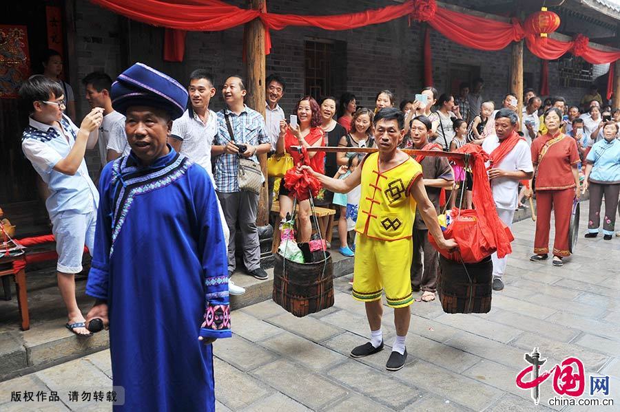 新郎家的“带队客总”带着聘礼，吹锣打鼓到新娘家取亲。中国网图片库 谢顺/摄