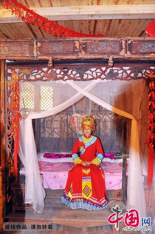 新娘坐在古色古香的新床上。中國網圖片庫 謝順/攝