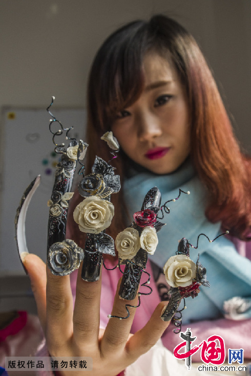 　2月13日，一名美甲艺术工作者在展示情人节主题的指甲。中国网图片库 封疆江摄