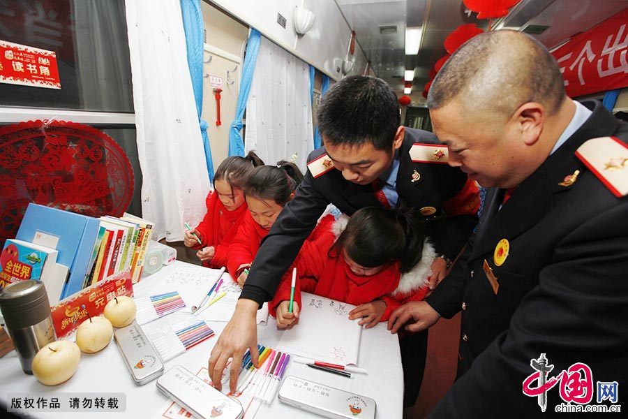 2月5日11时许，在成都开往杭州的3338次列车餐车读书角里，青年志愿者们与三胞胎姐妹唐晓林、唐晓金、唐晓银一起画出新年愿望。
