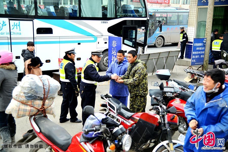 2月11日，珠三角返乡“铁骑”民工抵达四川省泸州市叙永县境内，民警为铁骑民工递上热茶。