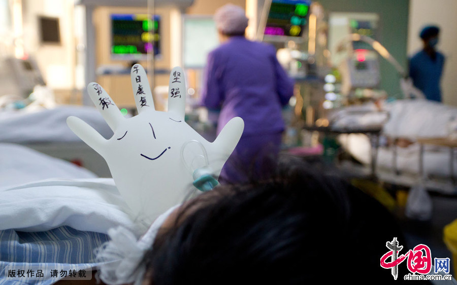  2015年2月7日，鄭州，對一些意識清楚的病人，醫護人員也會“賣個萌”，將手套吹成氣球的形狀，寫上一些鼓勵的話，為病人加油鼓氣，讓病房多了一些生氣。 圖片來源：CFP