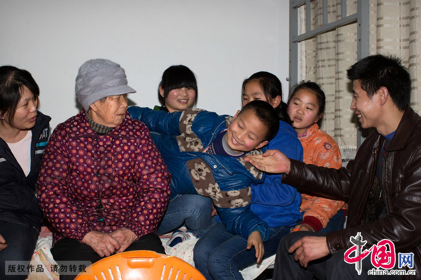  2014年1月31日，大年初一。重庆主城南岸区。孩子们在父母的出租屋里跟父母玩耍。图片作者:三季/CFP