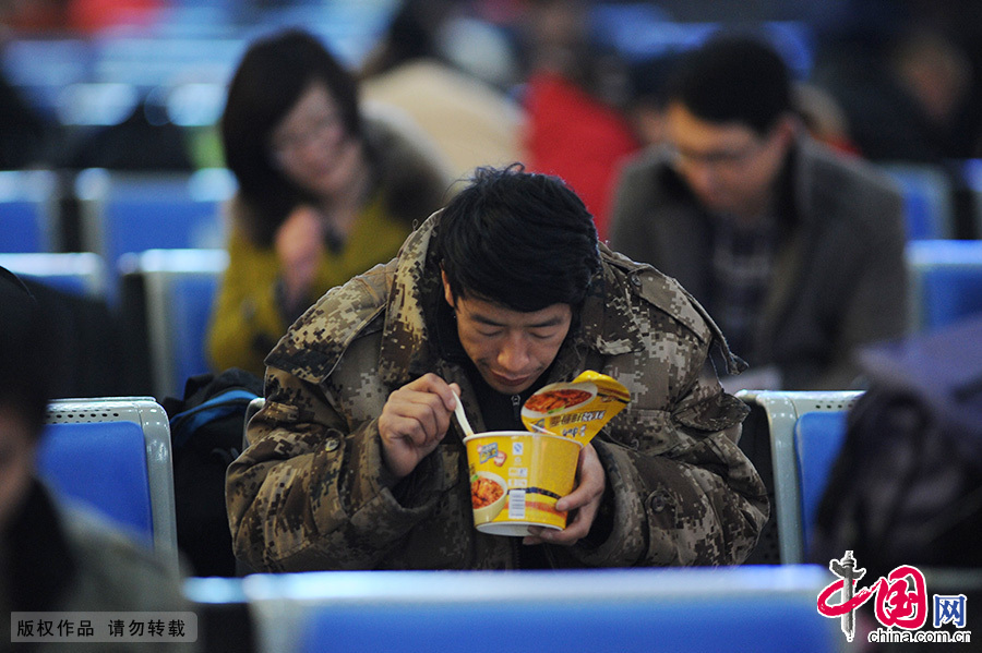 2015年2月15日，一盒面的午餐，图为青岛火车站的候车旅客。中国网图片库 王海滨/摄　　